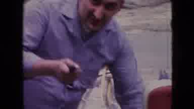 Athens Ohio USA (1966): Man Repairing Motorbike On Side Of Road A Red Scooter