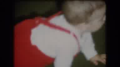 Athens Ohio USA (1966): A Baby In White And Red Clothes Is Crawling Right Next To
