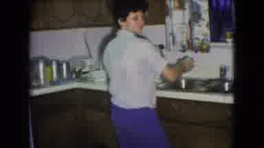 Athens Ohio USA (1966): Woman In Kitchen Shaking Object Over Double Sink Turns
