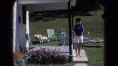 Athens Ohio USA (1966): Woman In Blue Top Standing On Porch In Front Of Lawn