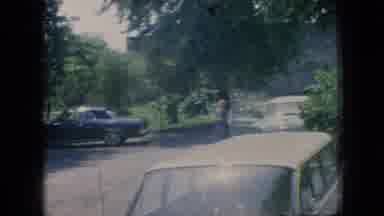 New Jersey USA (1966): People Walk Down A Road Lined With Parked Cars In A