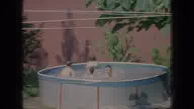 New Jersey USA (1966): Young Men Swimming While Friends Play Catch With Football