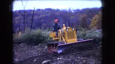 Ohio USA (1966): A Man Operates A Bulldozer Near A House In The Winter