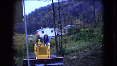 Ohio USA (1966): Two People Riding A Tractor In Their Yard
