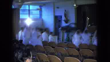 Ohio USA (1966): Two Women In White Dresses Walk Down Aisle Along Many Other Women