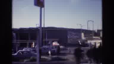 Portugal (1972): A Moving Vehicle Drives Past Parking Lots And Homes In An Urban