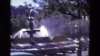Portugal (1972): A Water Fountain Surrounded By Cars A Storefront And A City By A
