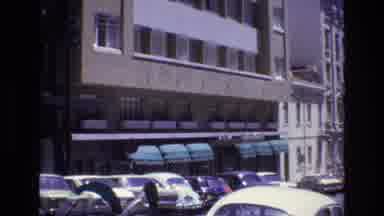Portugal (1972): Parked Car On Busy Street In Front Of Large Building As A Car