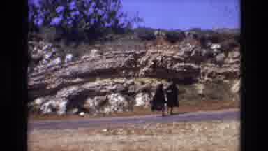 Portugal (1972): Two Women In Black Cloaks Walking Alongside A Road