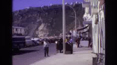 Portugal (1972): People Standing On Side Of The Street With Mountain In The