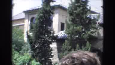 Spain (1972): People Gather In Front Of An Old Building Made Of Stone With A