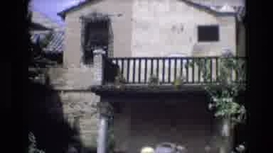 Spain (1972): Man In Grey Hat Walking Near Old House On Sunny Day