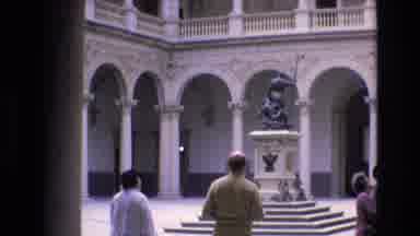 Spain (1972): People Walking By Statue