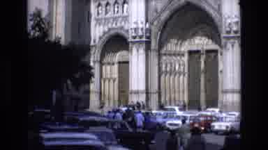 Spain (1972): People Walking Towards Grand Cathedral Showing Cars Parked Out Front