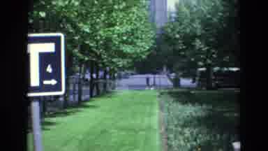Spain (1972): Street With Few Cards Next To A Park With A Sprinkler Watering