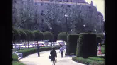 Spain (1972): People Walking In Manicured Park Near Large Castle-Like Building