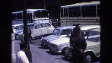 Spain (1972): People Standing In Front Of Parked Cars