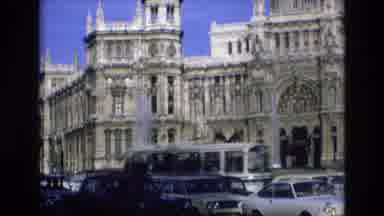 Spain (1972): Automobile Traffic Passes In Front Of A Large Old Building With