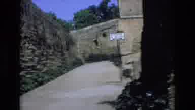 Spain (1972): Man In Purple And Woman In Red Walk Down Road
