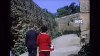 Spain (1972): Men And Women Congregate And Walk Near High Stone Walls And