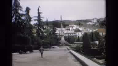 Spain (1972): Man Dressed In A Suit Walking Toward A Meticulously Manicured City