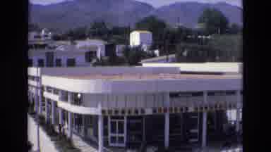 Spain (1972): People Walking On The Road Around The Building With A Peaceful City