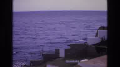Spain (1972): Buildings And Shelters Stand On A Coastal Area As The Tide Drives In