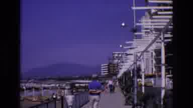 Spain (1972): A Man Walking Down The Boardwalk By The Water