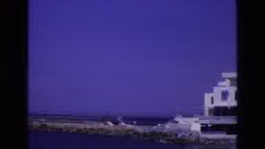 Spain (1972): A Building Next To The Ocean With A Dock Leading Out Of It