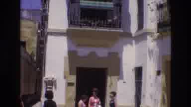 Spain (1972): White Building With People Outside That Look Like Tourists