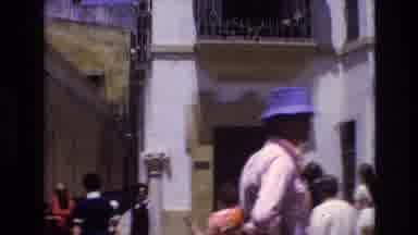 Spain (1972): A Person Standing And Watching A Crowd Of People Go By
