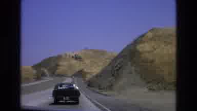 Central Coast California USA (1973): Car Speeding Down Road Headed For Curve