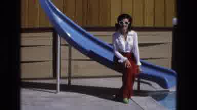 Central Coast California USA (1973): A Woman Sitting On A Water Slide Relaxing By