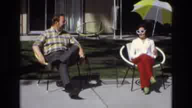 Central Coast California USA (1973): Couple Sitting In Sun With Woman Taking Off