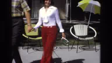 Central Coast California USA (1973): A Couple Walk Past Chairs And An Umbrella On