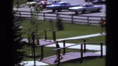 Colorado USA (1973): A Running Boy Crosses A Bridge And Up Concrete Steps While A