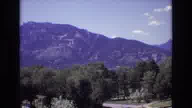 Colorado USA (1973): Mountains In Background Tall Trees Man Standing In Pool Women