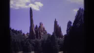 Colorado USA (1973): Rocky Peaks Rise Above A Conifer Forest Underneath A