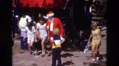 Colorado USA (1973): A Man Dressed Like Santa Claus Walks With Children In Warm