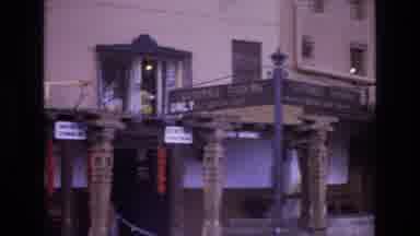 New Mexico USA (1973): Cars Pass By A Building That Has Decorative Posts Lining