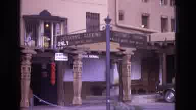 New Mexico USA (1973): Person On Motorcycle Wearing White Helmet Drives By City