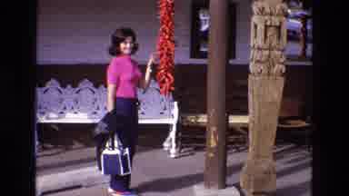 New Mexico USA (1973): Woman In Pink Shirt Standing Near String Of Red Peppers