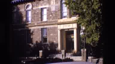 New Mexico USA (1973): A Brick Building Leading To A Path Lined With Trees