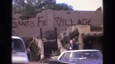 New Mexico USA-1973: A Man Stands In Front Of Santa Fe Village Building With Classic Cars