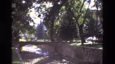 New Mexico USA (1973): Canal And Bridge In Park Setting With Car Passing On Street
