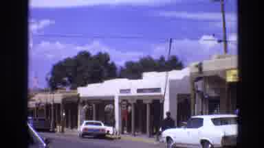 New Mexico USA (1973): Car Driving Down Street With Shops