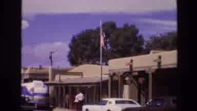 New Mexico USA (1973): Flag Outside Building With Lots Of Cars And People