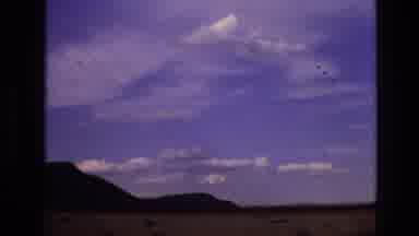 New Mexico USA (1973): Driving Down Road Looking At Clouds In Sky