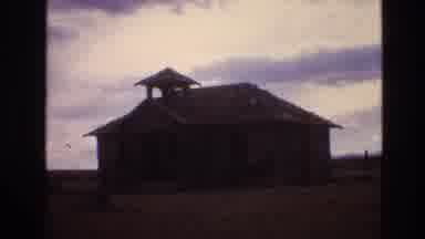 New Mexico USA (1973): Run-Down Buildings Stand On A Rural Plain Under A Cloudy