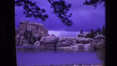 South Dakota USA (1974): A Scenery Of Trees And Rocky Mountains With A Lake